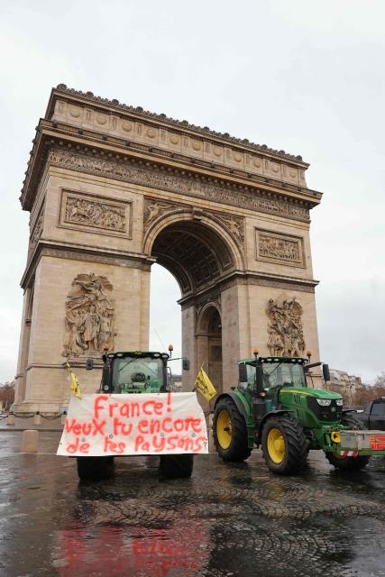Tractors including one with a banner reading "France! Do you still want your farmers?" are seen parked in front of the Arc de Triomphe during a demonstration of French agricultural union Coordination Rurale (CR) as part of a nationwide day of protests and actions called by several farmers unions to push the French government to block the Mercosur trade deal and protest against its handling of the nodular dermatitis (CND) epidemic, in Paris on January 8, 2026. (Photo by Thomas SAMSON / AFP)