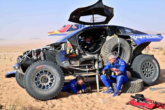 Ford Racing’s Spanish driver Carlos Sainz (R) and Spanish co?pilot Lucas Cruz are pictured at the refeul bivouac at the end of  the Stage 4, a Marathon stage, of the 48th edition of the Dakar Rally 2026, between Al-Ula and Al-Ula, Saudi Arabia, on January 7, 2026. (Photo by Giuseppe CACACE / AFP)