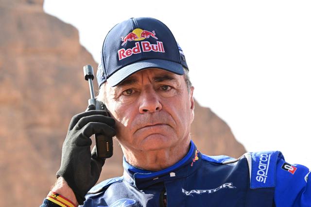 Ford Racing’s Spanish driver Carlos Sainz Speacks on the phone at the end of  the Stage 4, a Marathon stage, of the 48th edition of the Dakar Rally 2026, between Al-Ula and Al-Ula, Saudi Arabia, on January 7, 2026. (Photo by Giuseppe CACACE / AFP)