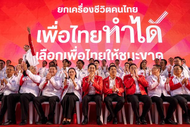 Pheu Thai Party prime ministerial candidate Yodchanan Wongsawat (C) and former Prime Minister Paetongtarn Shinawatra (centre, L) sit together on stage during the party’s first major rally at Lan Khon Mueang in Bangkok on January 8, 2025. (Photo by Chanakarn Laosarakham / AFP)