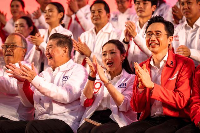 Pheu Thai Party prime ministerial candidate Yodchanan Wongsawat (R) and former Prime Minister Paetongtarn Shinawatra (C) sit together on stage during the party’s first major rally at Lan Khon Mueang in Bangkok on January 8, 2025. (Photo by Chanakarn Laosarakham / AFP)