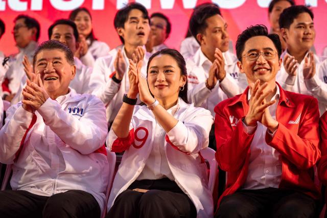 Pheu Thai Party prime ministerial candidate Yodchanan Wongsawat (R) and former Prime Minister Paetongtarn Shinawatra (C) sit together on stage during the party’s first major rally at Lan Khon Mueang in Bangkok on January 8, 2025. (Photo by Chanakarn Laosarakham / AFP)