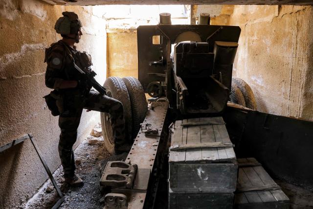 (FILES) A peacekeeper of the United Nations Interim Force in Lebanon (UNIFIL) stands by an artillery gun at a fortified position formerly held Iran-backed Hezbollah in the Khraibeh Valley in el-Meri in south Lebanon on August 27, 2025. Lebanon's army said on Januray 8, 2026, that it had completed the first phase of its plan to disarm Hezbollah in south Lebanon, while Israel called the efforts encouraging but "far from sufficient". Under heavy US pressure and amid fears of expanded Israeli strikes, Lebanon has committed to disarming the Iran-backed militant group, which was badly weakened after more than a year of hostilities including two months of all-out war that ended with a November 2024 ceasefire. (Photo by ANWAR AMRO / AFP)