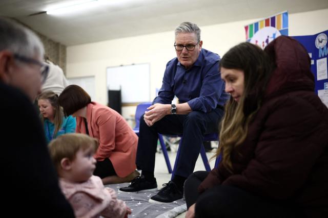 Britain's Prime Minister Keir Starmer (C) meets with Miranda Baker (R) and baby Lola (bottom L) during a visit to a "family hub" at St. Mary's Church Hall in Goldington, Bedfordshire, north of London on January 8, 2026, to highlight the government's work on child poverty and support families with the cost of living. (Photo by Henry NICHOLLS / AFP)