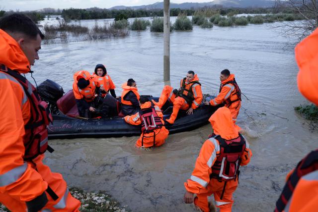 TOPSHOT - A woman sits on a lifeboat during her evacuation by members of the Civil Emergencies near the Vjosa River in the village of Novosele, near Vlore on January 8, 2026. Heavy rainfall in recent days has caused major flooding in cities, rivers overflowing their banks, and blockages on national roads across Albania. (Photo by Adnan Beci / AFP)