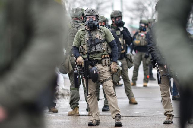 Federal agents stand guard as protestors gather outside the Bishop Henry Whipple Federal Building in Saint Paul, Minnesota, on January 8, 2026. A US Immigration and Customs Enforcement (ICE) agent shot and killed an American woman on the streets of Minneapolis January 7, leading to huge protests and outrage from local leaders who rejected White House claims she was a domestic terrorist. The woman, identified in local media as 37-year-old Renee Nicole Good, was hit at point blank range as she apparently tried to drive away from agents who were crowding around her car, which they said was blocking their way. (Photo by Octavio JONES / AFP)