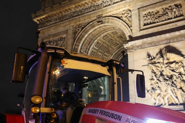 A CR farmer sits in a tractor parked in front of the Arc de Triomphe monument during a demonstration of the Coordination Rurale (CR) farmers union as part of a nationwide day of protests and actions called by several farmers unions to push the French government to block the Mercosur trade deal and protest against its handling of the nodular dermatitis (CND) epidemic, in Paris on January 8, 2026. (Photo by Alain JOCARD / AFP)