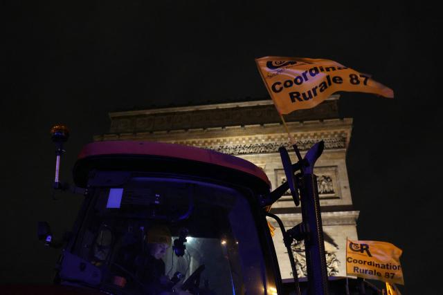 A CR farmer uses a smartphone in a tractor parked in front of the Arc de Triomphe monument during a demonstration of the Coordination Rurale (CR) farmers union as part of a nationwide day of protests and actions called by several farmers unions to push the French government to block the Mercosur trade deal and protest against its handling of the nodular dermatitis (CND) epidemic, in Paris on January 8, 2026. (Photo by Alain JOCARD / AFP)