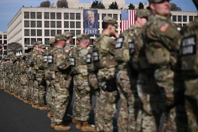 Members of the National Guard look on during a procession for Metropolitan Police Department (MPD) officer Terry Bennett, who passed away on January 7 after being struck on a highway while helping a stranded driver on December 23, 2025, in Washington, DC, on January 8, 2026. (Photo by Brendan SMIALOWSKI / AFP)