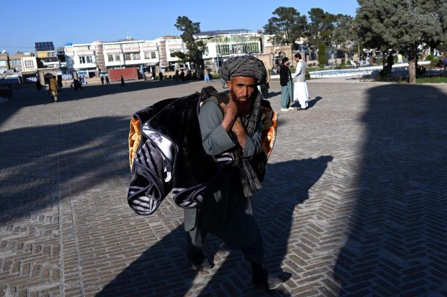 An Afghan vendor selling blankets walks outside the Grand Mosque in Herat on January 8, 2026. (Photo by Wakil KOHSAR / AFP)