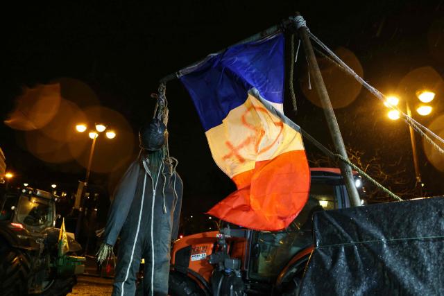 This photograph shows a dummy hanged with a a French flag displayed on a tractor in front of the Arc de Triomphe monument during a demonstration of the Coordination Rurale (CR) farmers union as part of a nationwide day of protests and actions called by several farmers unions to push the French government to block the Mercosur trade deal and protest against its handling of the nodular dermatitis (CND) epidemic, in Paris on January 8, 2026. (Photo by Alain JOCARD / AFP)