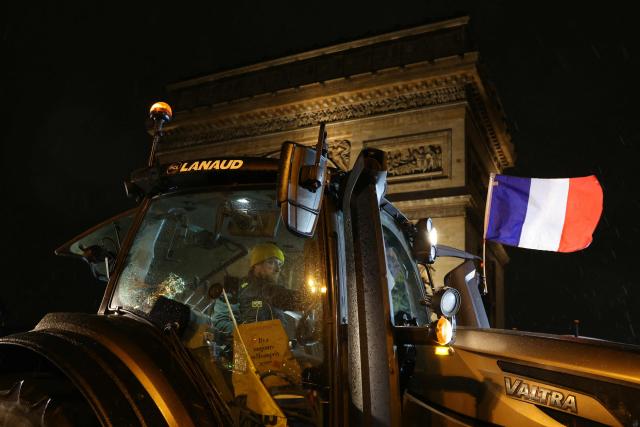 A CR farmer sits in a tractor with a French flag parked in front of the Arc de Triomphe monument during a demonstration of the Coordination Rurale (CR) farmers union as part of a nationwide day of protests and actions called by several farmers unions to push the French government to block the Mercosur trade deal and protest against its handling of the nodular dermatitis (CND) epidemic, in Paris on January 8, 2026. (Photo by Alain JOCARD / AFP)