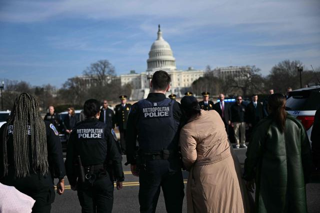 Members of the Metropolitan Police Department (MPD) look on during a procession for MPD officer Terry Bennett, who passed away on January 7 after being struck on a highway while helping a stranded driver on December 23, 2025, in Washington, DC, on January 8, 2026. (Photo by Brendan SMIALOWSKI / AFP)