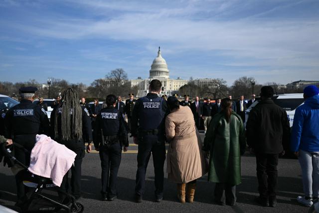 Members of the Metropolitan Police Department (MPD) look on during a procession for MPD officer Terry Bennett, who passed away on January 7 after being struck on a highway while helping a stranded driver on December 23, 2025, in Washington, DC, on January 8, 2026. (Photo by Brendan SMIALOWSKI / AFP)