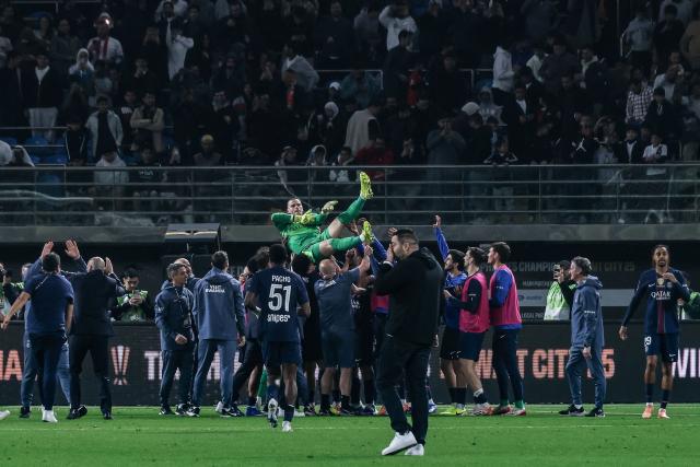 Paris Saint-Germain's French goalkeeper #30 Lucas Chevalier (C) is lifted by teammates after PSG won following a penalty shoot-out in the French Champions' Trophy (Trophee des Champions) football match between Paris Saint-Germain (PSG) and Olympique de Marseille (OM) at the Jaber Al-Ahmad International Stadium in Kuwait City on January 8, 2026. (Photo by YASSER AL-ZAYYAT / AFP)