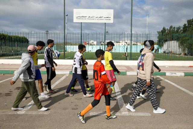 Youths walk to the municipal football field named after Moroccan international Achraf Hakimi in Ksar El-Kebir in northern Morocco on January 8, 2026. (Photo by Abdel Majid BZIOUAT / AFP)