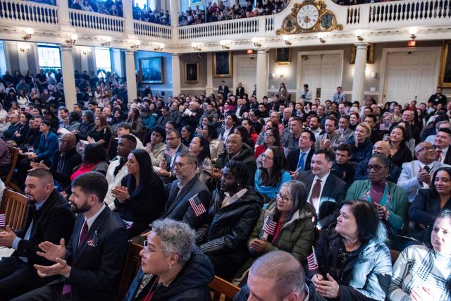 New citizens wave US flags as the judge calls out the countries they came from at Faneuil Hall in Boston, Massachusetts on January 8, 2026. (Photo by Joseph Prezioso / AFP)