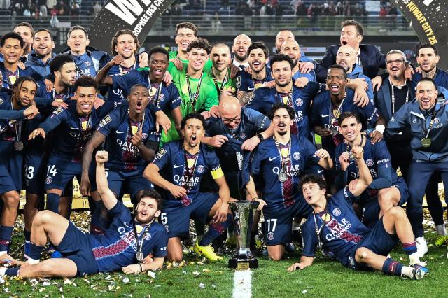 PSG's players celebrate with the trophy after winning the French Champions' Trophy (Trophee des Champions) football match between Paris Saint-Germain (PSG) and Olympique de Marseille (OM) at the Jaber Al-Ahmad International Stadium in Kuwait City on January 8, 2026. (Photo by YASSER AL-ZAYYAT / AFP)