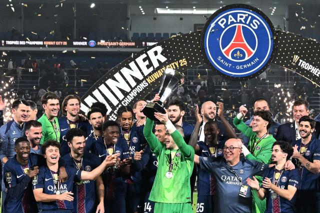 PSG's players celebrate with the trophy after winning the French Champions' Trophy (Trophee des Champions) football match between Paris Saint-Germain (PSG) and Olympique de Marseille (OM) at the Jaber Al-Ahmad International Stadium in Kuwait City on January 8, 2026. (Photo by YASSER AL-ZAYYAT / AFP)