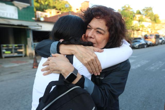 Venezuelan human rights lawyer Karelys Fernandez (R) hugs a relative of prisoners in front of El Rodeo jail in Caracas on January 8, 2026. Venezuelan authorities are releasing a "large number" of prisoners, some of them foreigners, five days after US forces ousted authoritarian leader Nicolas Maduro, parliament speaker Jorge Rodriguez said o January 8. (Photo by Pedro MATTEY / AFP)
