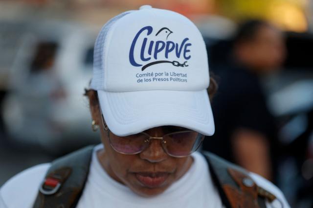 A woman wearing a hat of Clippve (Committee for the Freedom of Political Prisoners) is pictured outside of El Rodeo jail in Caracas on January 8, 2026. Venezuelan authorities are releasing a "large number" of prisoners, some of them foreigners, five days after US forces ousted authoritarian leader Nicolas Maduro, parliament speaker Jorge Rodriguez said o January 8. (Photo by Pedro MATTEY / AFP)
