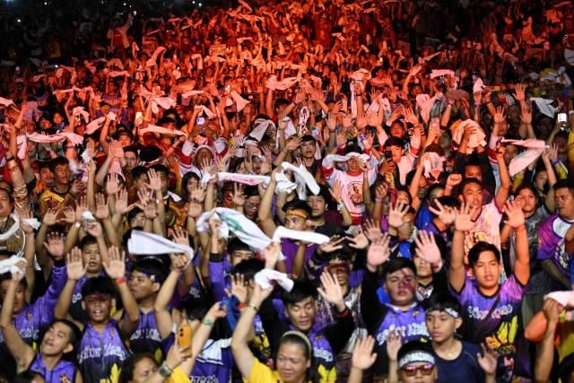 Philippine catholic devotees wave white towels and handkerchiefs during mass prior the annual religious procession of the image of Jesus Nazareno in Manila on January 9, 2026. (Photo by TED ALJIBE / AFP)