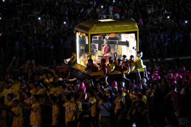 Philippine catholic devotees join along with the carriage carrying the image of Jesus Nazarene during the annual religious procession in Manila on January 9, 2026. (Photo by TED ALJIBE / AFP)