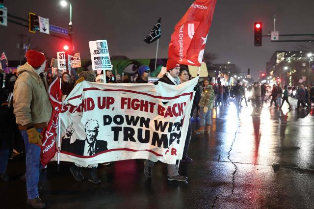 People march behind an anti-Trump banner during a "Stop ICE Terror" emergency protest in Minneapolis, Minnesota, on January 8, 2026. A US Immigration and Customs Enforcement (ICE) agent shot and killed an American woman on the streets of Minneapolis January 7, leading to huge protests and outrage from local leaders who rejected White House claims she was a domestic terrorist. The woman, identified in local media as 37-year-old Renee Nicole Good, was hit at point blank range as she apparently tried to drive away from agents who were crowding around her car, which they said was blocking their way. (Photo by CHARLY TRIBALLEAU / AFP)