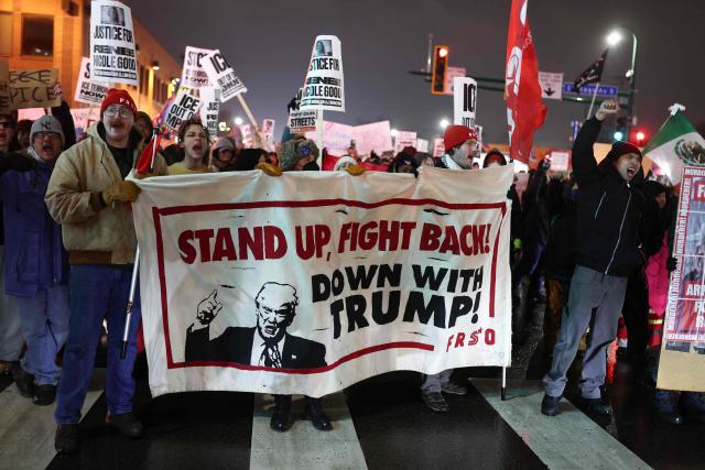 People march behind an anti-Trump banner during a "Stop ICE Terror" emergency protest in Minneapolis, Minnesota, on January 8, 2026. A US Immigration and Customs Enforcement (ICE) agent shot and killed an American woman on the streets of Minneapolis January 7, leading to huge protests and outrage from local leaders who rejected White House claims she was a domestic terrorist. The woman, identified in local media as 37-year-old Renee Nicole Good, was hit at point blank range as she apparently tried to drive away from agents who were crowding around her car, which they said was blocking their way. (Photo by CHARLY TRIBALLEAU / AFP)