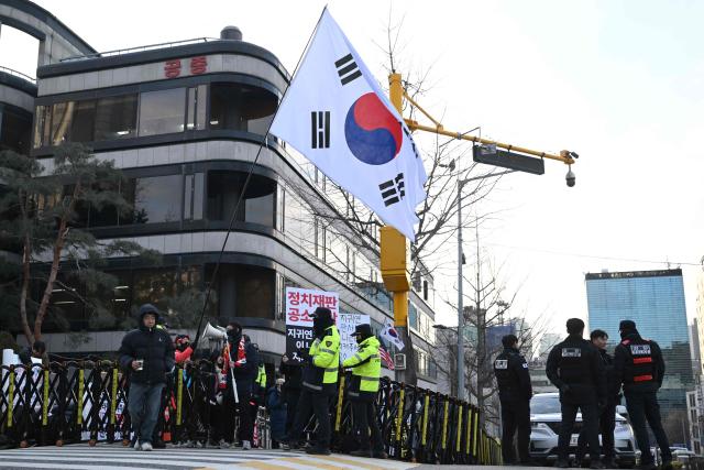 Supporters of South Korea's former impeached president Yoon Suk Yeol gather in front of the Seoul Central District Court in Seoul on January 9, 2026, as Yoon's final criminal trial on insurrection charges is held in the court. (Photo by Jung Yeon-je / AFP)