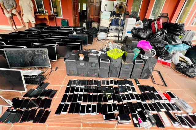 (FILES) This pool photo taken on July 17, 2025 and released on July 18 by Agence Kampuchea Presse (AKP) shows computers, smartphones and other equipment seized during a raid on a scam centre in Kandal province. China is moving against the cyberscam tycoons making fortunes in Southeast Asia, driven by mounting public pressure and Beijing's desire to keep control of judicial processes, analysts say. 
In 2025, a series of crackdowns largely driven by Beijing -- which wields significant economic and diplomatic influence in the region -- saw thousands of workers released from scam centres in Myanmar and Cambodia and repatriated to their home countries, many of them to China.
Now Beijing has turned its focus to the bosses at the apex of the criminal pyramids, netting its biggest player so far with the arrest and extradition of Chen Zhi from Cambodia in January 2026. (Photo by POOL / AFP)