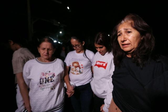 Relatives of prisoners take part in a prayer as they wait in front of El Rodeo jail in Caracas on January 9, 2026. Venezuelan authorities are releasing a "large number" of prisoners, some of them foreigners, five days after US forces ousted authoritarian leader Nicolas Maduro, parliament speaker Jorge Rodriguez said on January 8. (Photo by Pedro MATTEY / AFP)