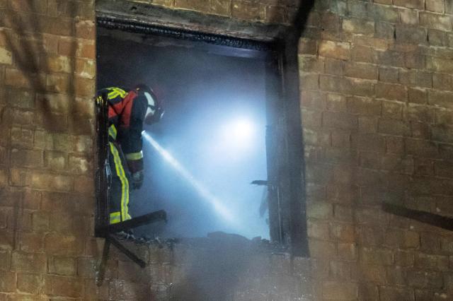 Ukrainian rescuers work to extinguish a fire in a heavily damaged residential building following a Russian drone and missile attacks in Kyiv early on January 9, 2026, amid the Russian invasion of Ukraine. (Photo by Serhii Okunev / AFP)