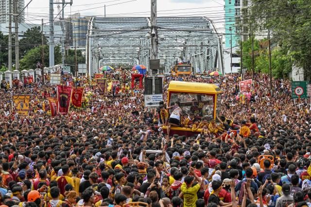 Catholic devotees join along with the carriage carrying the image of Jesus Nazareno, also known as Jesus the Nazarene, during the annual religious procession in Manila on January 9, 2026. Tens of thousands of Philippine Catholics twirled white cloths and chanted "Viva, viva" as a historic statue of Jesus Christ was paraded through the streets of Manila on January 9 in the nation's biggest annual religious event. (Photo by Jam STA ROSA / AFP)