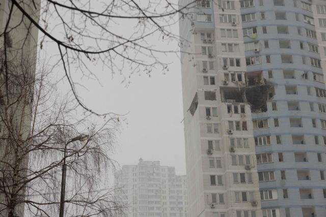 Firefighters clear debris in a damaged residential building following a Russian attack in Kyiv early on January 9, 2026, amid the Russian invasion of Ukraine. Russia launched a massive attack on Ukraine's capital, setting apartment blocks alight and killing at least four people, Kyiv's police said on January 9, 2026 after Moscow rejected the latest post-war peacekeeping plan. (Photo by Tetiana DZHAFAROVA / AFP)