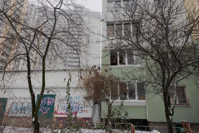 A man cleans up broken glass from his balcony following a Russian attack in Kyiv early on January 9, 2026, amid the Russian invasion of Ukraine. Russia launched a massive attack on Ukraine's capital, setting apartment blocks alight and killing at least four people, Kyiv's police said on January 9, 2026 after Moscow rejected the latest post-war peacekeeping plan. (Photo by Tetiana DZHAFAROVA / AFP)