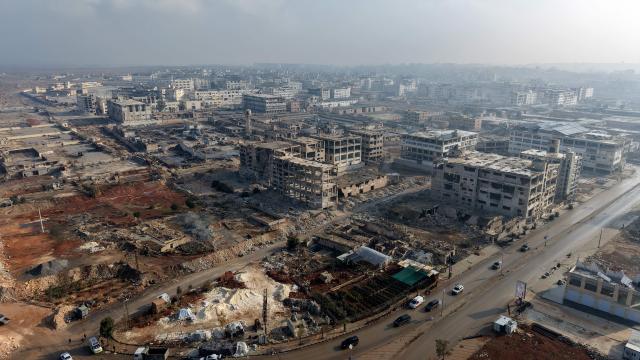 An aerial photograph shows buses as they enter from the Lairamoun roundabout towards the Sheikh Maqsud neighbourhood, to evacuate the US-backed Kurdish-led Syrian Democratic Forces (SDF) forces fighters from two districts of the city of Aleppo, northern Syria, on January 9, 2026. Kurdish fighters encircled by the Syrian army are to be sent to the Kurdish region of northeastern Syria, the Syrian authorities said January 9, 2026. Syria's defence ministry earlier announced a ceasefire in the city after several days of clashes and granted the Kurdish fighters a deadline to leave two districts they control. (Photo by Bakr ALKASEM / AFP)