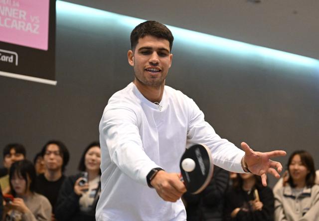Spain's Carlos Alcaraz plays table tennis with Italy's Jannik Sinner (not pictured) during a welcome event at Hyundai Card headquarters in Seoul on January 9, 2026, ahead of a tennis exhibition match between Jannik Sinner and Carlos Alcaraz. (Photo by Jung Yeon-je / AFP)