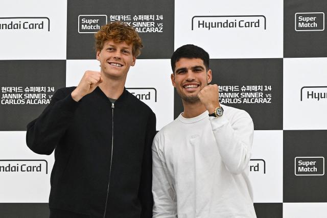 Italy's Jannik Sinner (L) and Spain's Carlos Alcaraz pose for a photo during a press conference at Hyundai Card headquarters in Seoul on January 9, 2026, ahead of their tennis exhibition match. (Photo by Jung Yeon-je / AFP)