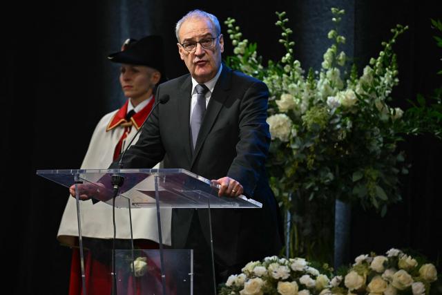 Swiss Federal President Guy Parmelin delivers remarks at the tribute ceremony for the victims of the deadly fire that ripped through the bar Le Constellation in Crans-Montana on New Year's Eve, in Martigny, on January 9, 2026. All of Switzerland will mark a national day of mourning on January 9 for the dozens of mostly teenagers killed when fire ravaged a ski resort bar crammed with New Year revellers. Just over a week after the tragedy at the Le Constellation bar in Crans-Montana, which left 40 dead and 116 injured, the wealthy Alpine nation will come to a standstill for a minute of silence at 2:00 pm (1300 GMT). (Photo by Fabrice COFFRINI / POOL / AFP)