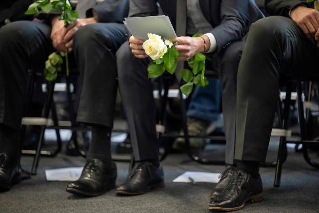 State Councillor and president of the Council of State of the Canton of Valais Mathias Reynard holds a white rose as he reviews his speech before speaking during a tribute ceremony for the victims of the deadly fire that ripped through the bar Le Constellation in Crans-Montana on New Year's Eve, in Martigny, on January 9, 2026. All of Switzerland will mark a national day of mourning on January 9 for the dozens of mostly teenagers killed when fire ravaged a ski resort bar crammed with New Year revellers. Just over a week after the tragedy at the Le Constellation bar in Crans-Montana, which left 40 dead and 116 injured, the wealthy Alpine nation will come to a standstill for a minute of silence at 2:00 pm (1300 GMT). (Photo by LAURENT GILLIERON / POOL / AFP)