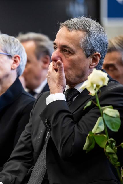 Swizterland's Foreign Minister Ignazio Cassis reacts during a tribute ceremony for the victims of the deadly fire that ripped through the bar Le Constellation in Crans-Montana on New Year's Eve, in Martigny, on January 9, 2026. All of Switzerland will mark a national day of mourning on January 9 for the dozens of mostly teenagers killed when fire ravaged a ski resort bar crammed with New Year revellers. Just over a week after the tragedy at the Le Constellation bar in Crans-Montana, which left 40 dead and 116 injured, the wealthy Alpine nation will come to a standstill for a minute of silence at 2:00 pm (1300 GMT). (Photo by LAURENT GILLIERON / POOL / AFP)