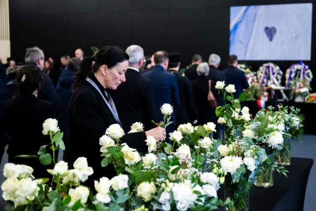 Swiss Federal Vice chancellor and Federal Council Spokesperson Nicole Lamon lays a white rose at the end of a tribute ceremony for the victims of the deadly fire that ripped through the bar Le Constellation in Crans-Montana on New Year's Eve, in Martigny, on January 9, 2026. All of Switzerland will mark a national day of mourning on January 9 for the dozens of mostly teenagers killed when fire ravaged a ski resort bar crammed with New Year revellers. Just over a week after the tragedy at the Le Constellation bar in Crans-Montana, which left 40 dead and 116 injured, the wealthy Alpine nation will come to a standstill for a minute of silence at 2:00 pm (1300 GMT). (Photo by LAURENT GILLIERON / POOL / AFP)
