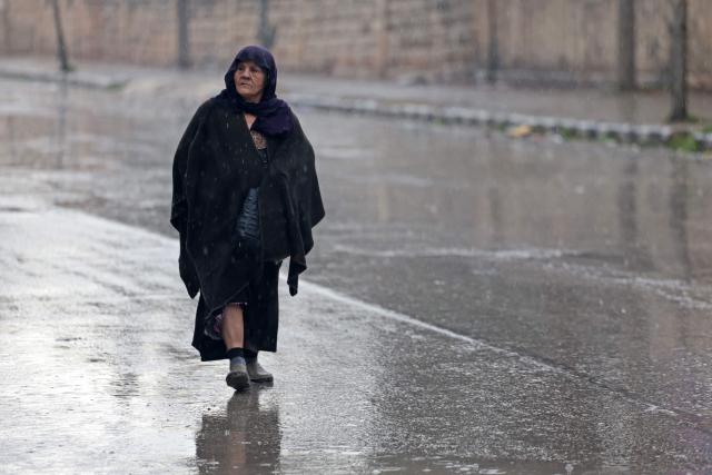 A resident of Aleppo's Sheikh Maqsoud area evacuates her neighbourhood after warnings from the Syrian army that called on civilians to get out of harms way, following the refusal of Kurdish fighter forces to leave Aleppo, on January 9, 2026. Syria's army warned on January 9 it would renew attacks against a Kurdish-majority district of Aleppo and urged residents to evacuate, state media reported, hours after a ceasefire was announced. (Photo by OMAR HAJ KADOUR / AFP)