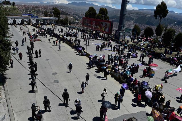 Members of Bolivia's teachers unions block the road linking El Alto-La Paz in protest against the elimination of hydrocarbon subsidies in Bolivia -now entering their third week- in El Alto, on January 9, 2026. Protests against centre-right President Rodrigo Paz’s economic measures, ending fuel subsidies and doubling petrol and diesel prices, have led to 32 roadblocks, several on major routes, according to the state-owned Bolivian Road Administration (ABC). (Photo by Jorge BERNAL / AFP)
