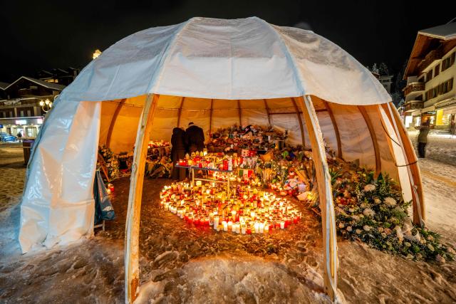 Attendees gather in mourning, placing messages, candles, and flowers at a memorial site in front of the bar “Le Constellation” during a national day of mourning in Crans-Montana, on January 9, 2026, in tribute to the victims of the fire that ravaged the bar on New Year’s Eve, killing 40 people and injuring 116 others, most of them teenagers. All of Switzerland will mark a national day of mourning on January 9 for the dozens of mostly teenagers killed when fire ravaged a ski resort bar crammed with New Year revellers. Just over a week after the tragedy at the Le Constellation bar in Crans-Montana, which left 40 dead and 116 injured, the wealthy Alpine nation will come to a standstill for a minute of silence at 2:00 pm (1300 GMT). (Photo by MAXIME SCHMID / AFP)
