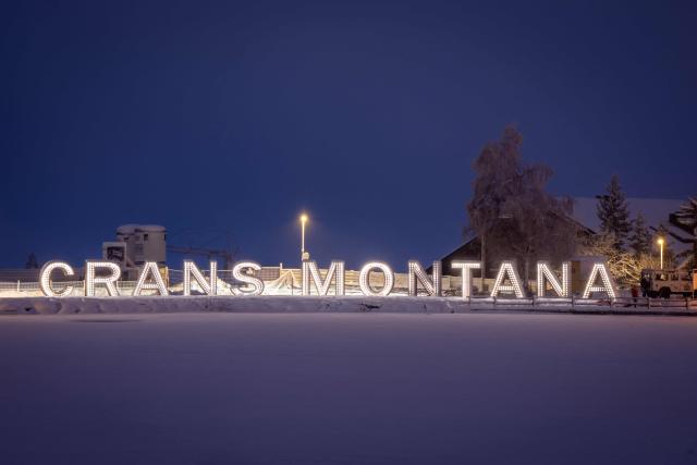 The illuminated letters of Crans-Montana are photographed at Etang de Grenon during a national day of mourning in Crans-Montana, on January 9, 2026, in tribute to the victims of the fire that ravaged the bar on New Years Eve, killing 40 people and injuring 116 others, most of them teenagers. All of Switzerland will mark a national day of mourning on January 9 for the dozens of mostly teenagers killed when fire ravaged a ski resort bar crammed with New Year revellers. Just over a week after the tragedy at the Le Constellation bar in Crans-Montana, which left 40 dead and 116 injured, the wealthy Alpine nation will come to a standstill for a minute of silence at 2:00 pm (1300 GMT). (Photo by MAXIME SCHMID / AFP)
