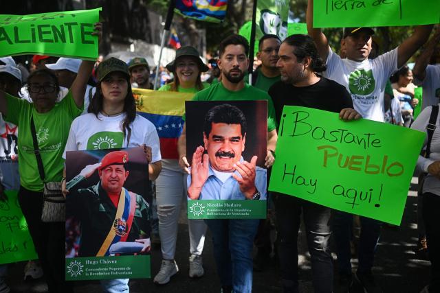 People hold images of deposed Venezuelan president Nicolas Maduro and former President Hugo Chavez during a march in Caracas on January 9, 2026, to demand the release of Maduro and his wife Cilia Flores, snatched and taken to New York on January 3 to face trial on drug and weapons charges. Colombia's President Gustavo Petro on January 9. urged Venezuela to jointly fight drug-traffickers operating across the two countries' border, after the United States threatened further armed action in the region. (Photo by Federico PARRA / AFP)