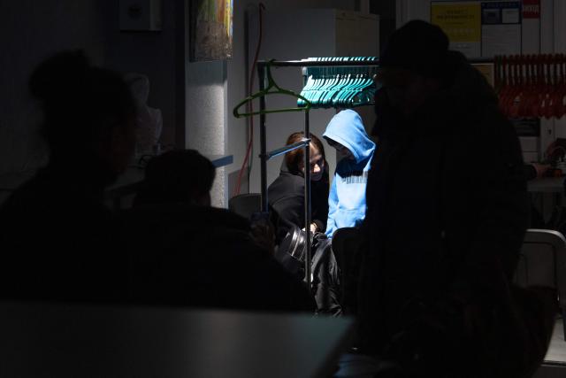 Local residents gather at the Point of Invincibility in Kyiv on January 9, 2026, where they can charge devices and warm themself, following Russian missile and drone attacks on Ukrainian energy infrastructure amid the Russian invasion of Ukraine. Mass heating outages caused by Russian strikes on Kyiv are set to last into the weekend, as the capital's mayor called on residents to temporarily leave the city with sub-zero temperatures expected to fall even lower. (Photo by Andrew Kravchenko / AFP)