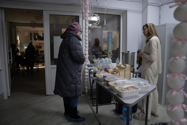 Local residents gather at the Point of Invincibility in Kyiv on January 9, 2026, where they can charge devices and warm themself, following Russian missile and drone attacks on Ukrainian energy infrastructure amid the Russian invasion of Ukraine. Mass heating outages caused by Russian strikes on Kyiv are set to last into the weekend, as the capital's mayor called on residents to temporarily leave the city with sub-zero temperatures expected to fall even lower. (Photo by Andrew Kravchenko / AFP)